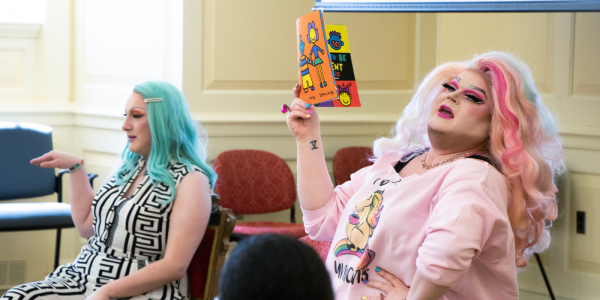 Performers Bella Naughty (left) and D'manda Martini (right) reading a book.