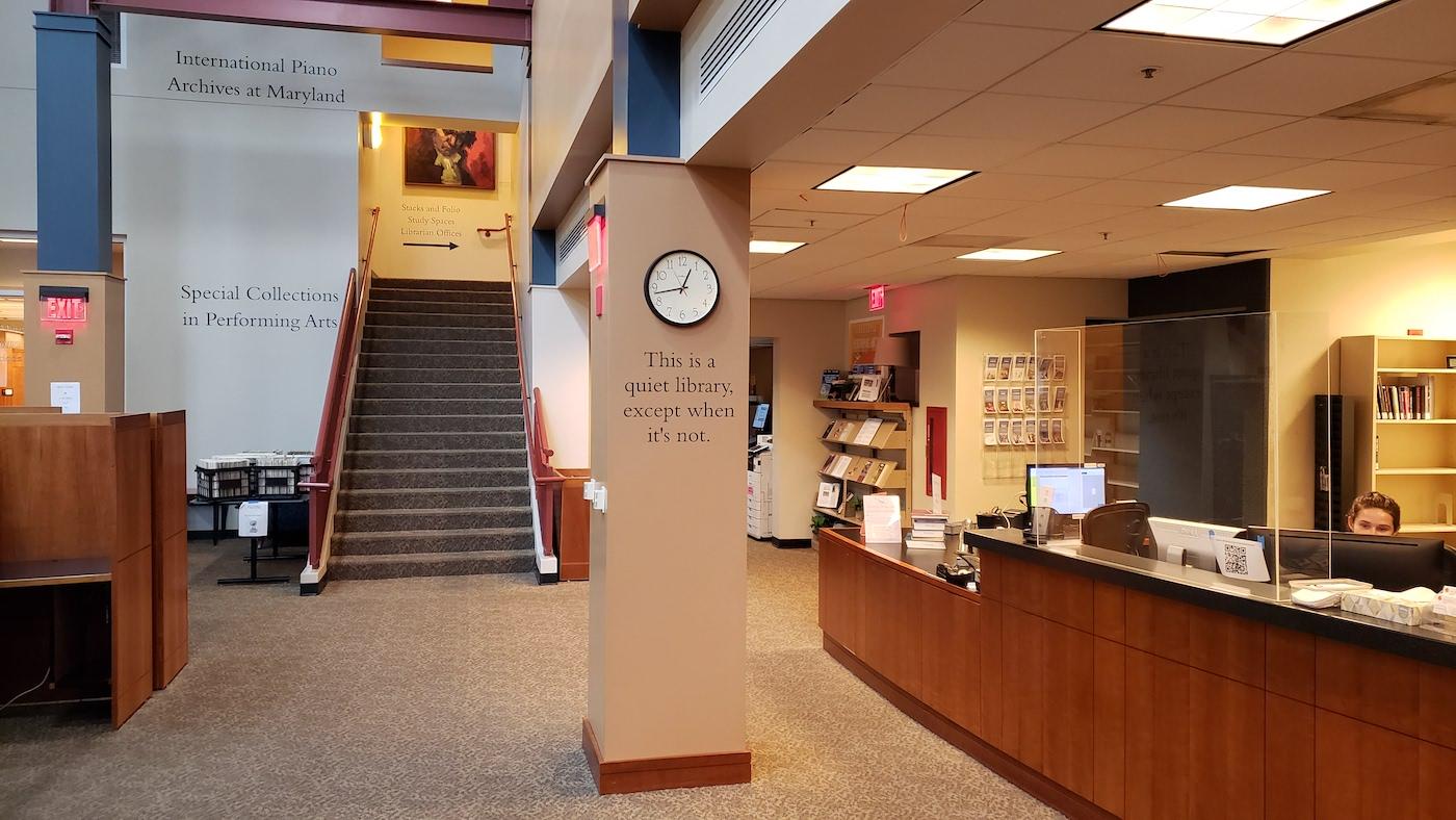 Circulation Desk of MSPAL with pillar that reads "This is a quiet library except when it's not."