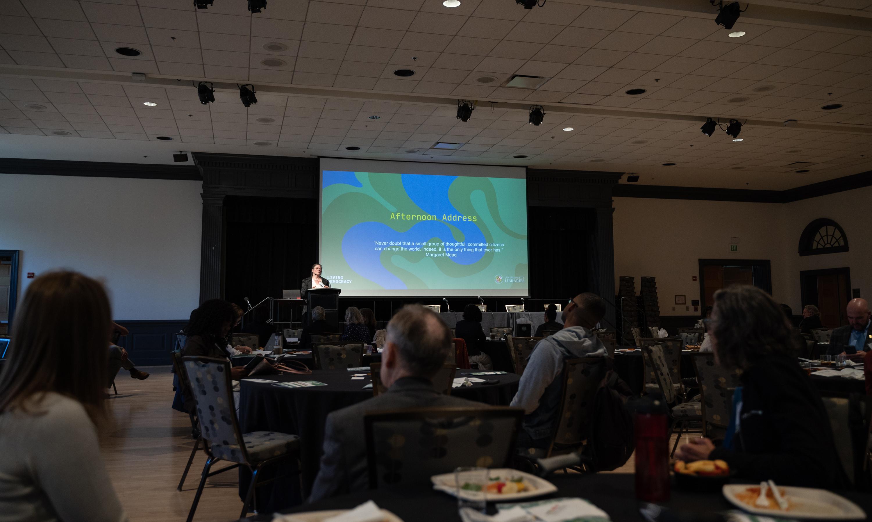 Wideshot of the stage and audience a the Living Democracy Symposium.